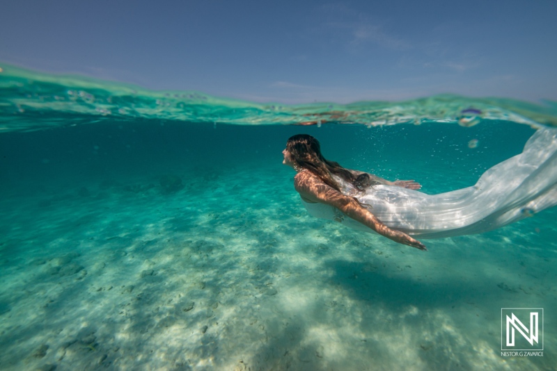 Underwater scene in Curacao showing a person swimming through clear water with flowing fabric