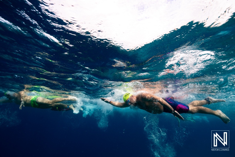 Swimmers glide through clear water in Curacao during a sunny day in the afternoon