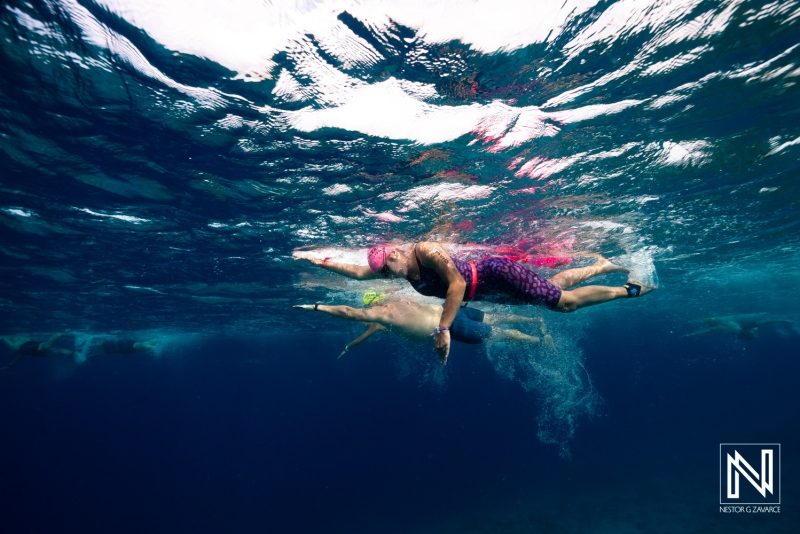Underwater scene in Curacao with swimmers enjoying the clear blue waters during a bright sunny day