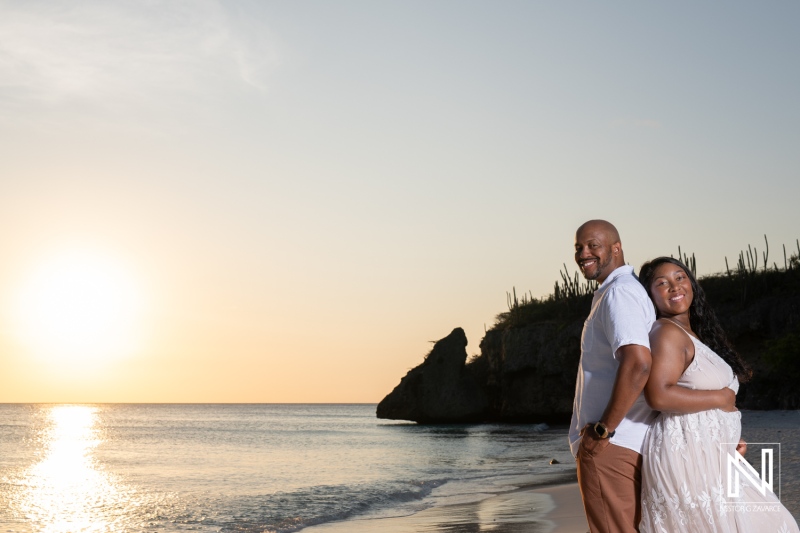 Couple celebrates vow renewal and announces pregnancy on the beach in Curacao at sunset