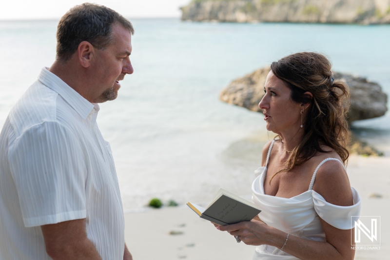 Couple celebrates vow renewal ceremony on sunny beach in Curacao with picturesque ocean backdrop and intimate moment