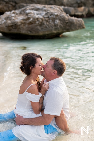 Couple embraces during vow renewal ceremony on the shores of Curacao's tranquil waters at sunset
