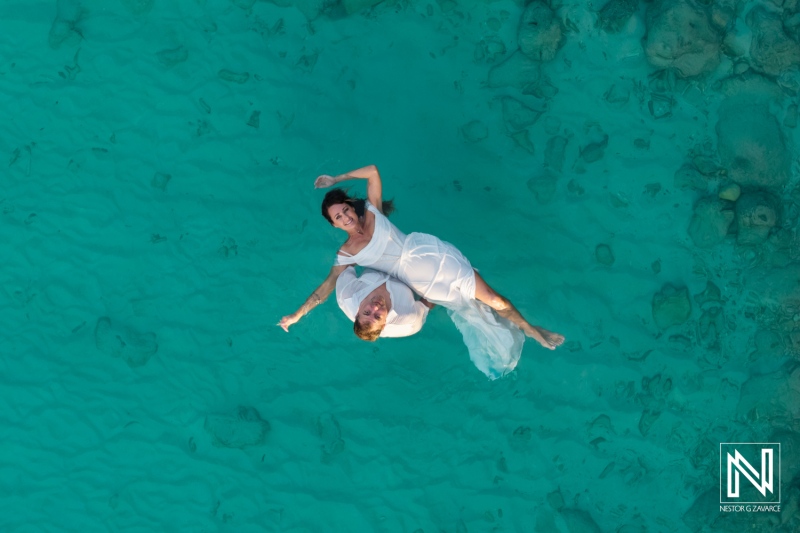 Couple celebrates vow renewal in beautiful turquoise waters of Curacao during a romantic afternoon