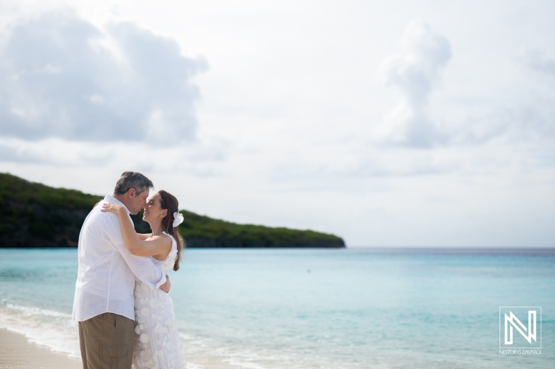 Couple celebrates vow renewal at Cas Abao Beach in Curacao with romantic backdrop of ocean and sky