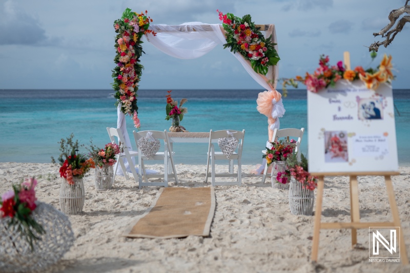 Vow renewal ceremony setup on Cas Abao Beach in Curacao surrounded by vibrant flowers and a serene ocean view