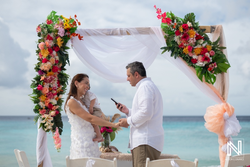 Couple renews vows on Cas Abao Beach in Curacao surrounded by vibrant flowers and family