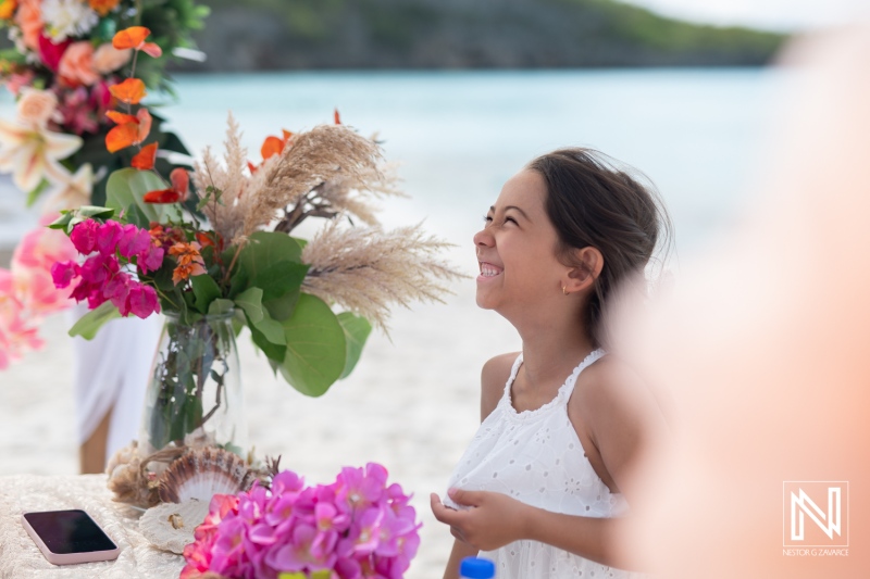 Smiles and joy during vow renewal celebration at Cas Abao Beach in Curacao, surrounded by beautiful tropical flowers