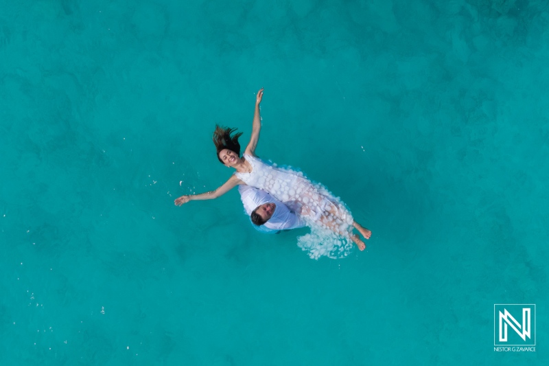 Couple joyfully celebrates vow renewal in turquoise waters of Cas Abao Beach, Curacao
