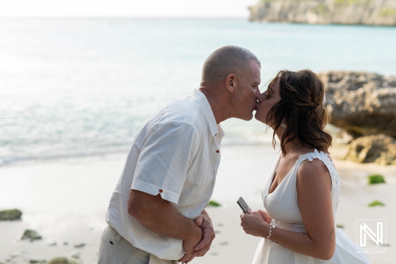 Couple celebrates vow renewal on a picturesque beach in Curacao at sunset, embracing love and commitment