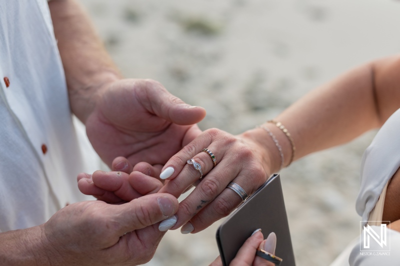 Vow renewal ceremony in Curacao with close-up of couple exchanging rings at sunset