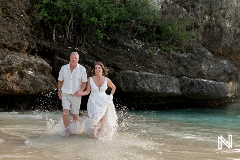 Couple joyfully renews their vows on a beautiful beach in Curacao during a bright sunny day