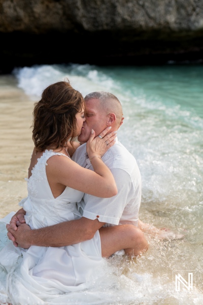 Couple celebrates vow renewal on the beach in Curacao during sunset, embracing the joy of love and commitment