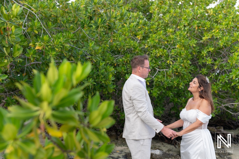 Couple celebrates vow renewal ceremony at Doggy Beach in Curacao surrounded by lush greenery and tranquil scenery