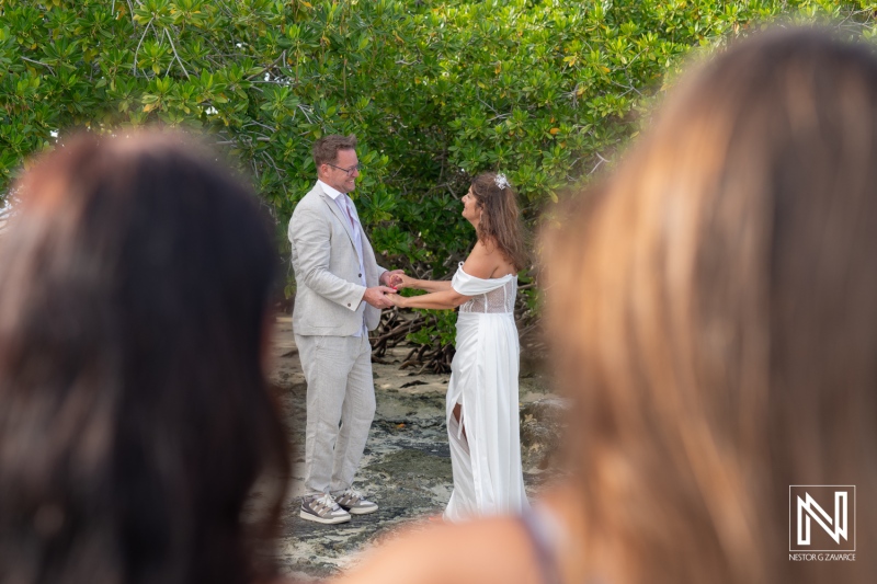 Couple exchanges vows during a heartfelt renewal ceremony at Doggy Beach in Curacao surrounded by lush greenery