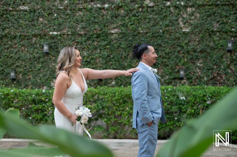 A Bride Surprises Her Groom During an Emotional First Look at an Elegant Outdoor Wedding Venue Surrounded by Lush Greenery