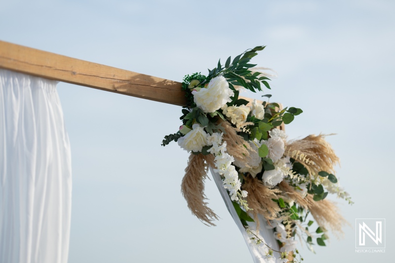 Elegant Floral Arrangement Adorning a Rustic Wooden Wedding Arch Beneath a Clear Sky at Sunset in an Outdoor Venue