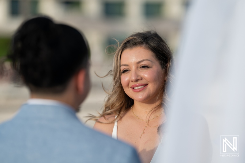 A Couple Smiling at Each Other During Their Intimate Wedding Ceremony by the Waterfront Under Clear Blue Skies in the Late Afternoon