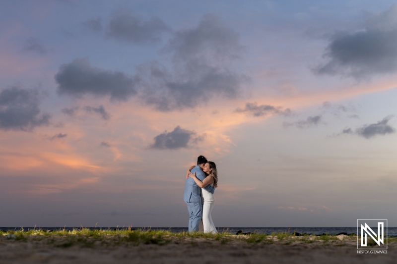 A Couple Embraces on the Beach at Sunset, Surrounded by Gentle Waves and Colorful Evening Clouds, Capturing a Romantic Moment of Love and Connection