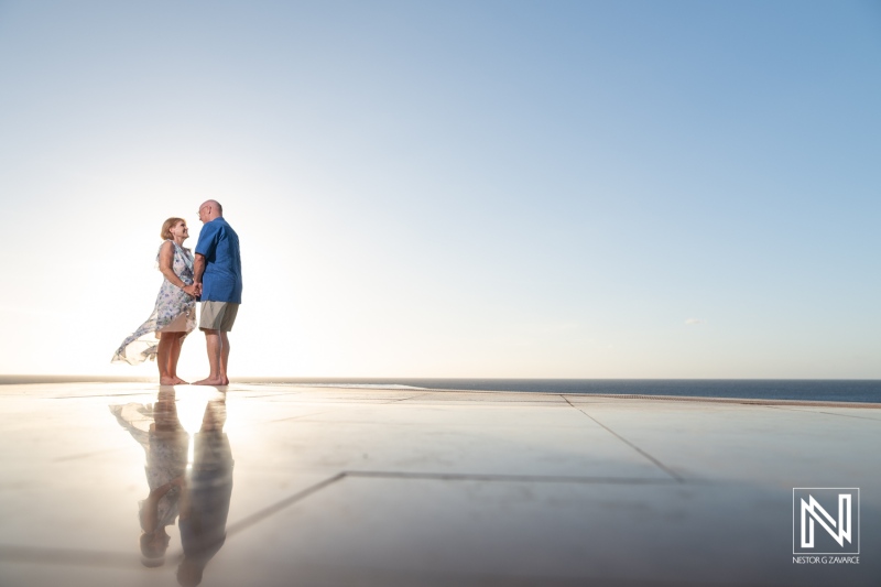 A Couple Enjoys a Romantic Moment on a Rooftop With an Ocean View at Sunset, Creating a Serene and Intimate Atmosphere