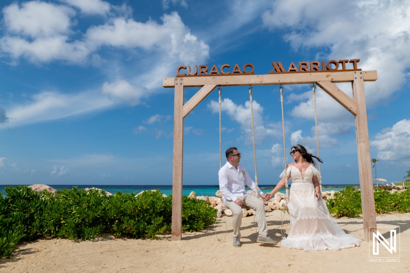 Couple celebrates vow renewal at Curacao Marriott Beach Resort swing near beach