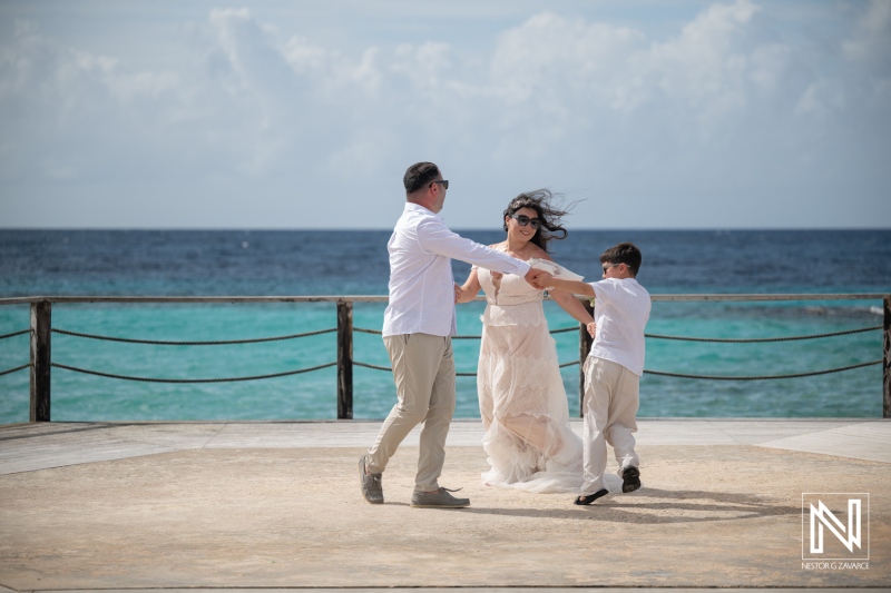 Couple and child celebrate vow renewal at Curacao Marriott Beach Resort near the ocean