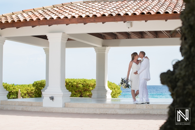 Bride and groom kissing in the beach gazebo