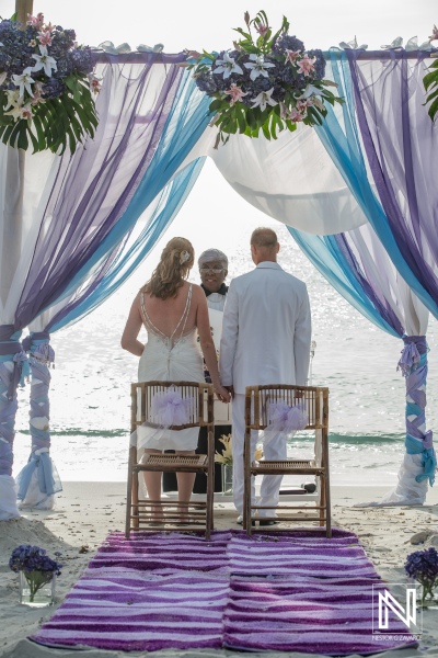 Bride and groom in their beach wedding ceremony with the officiant in a beautiful gazebo