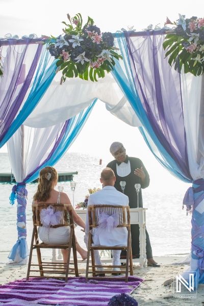 Bride and groom in their beach wedding ceremony with the officiant in a beautiful gazebo