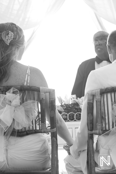 Bride and groom in their beach wedding ceremony with the officiant