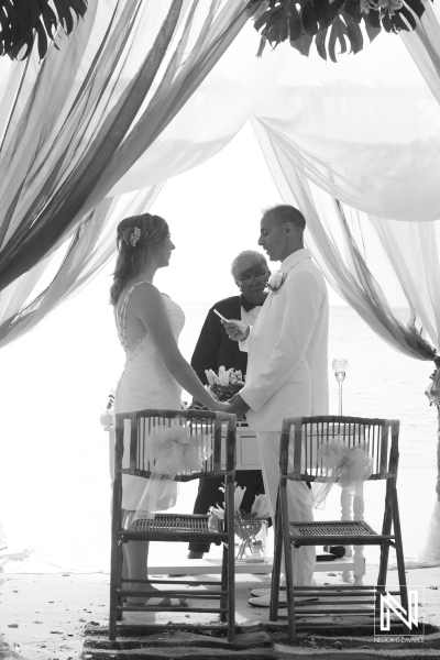 Bride and groom in their beach wedding ceremony with the officiant