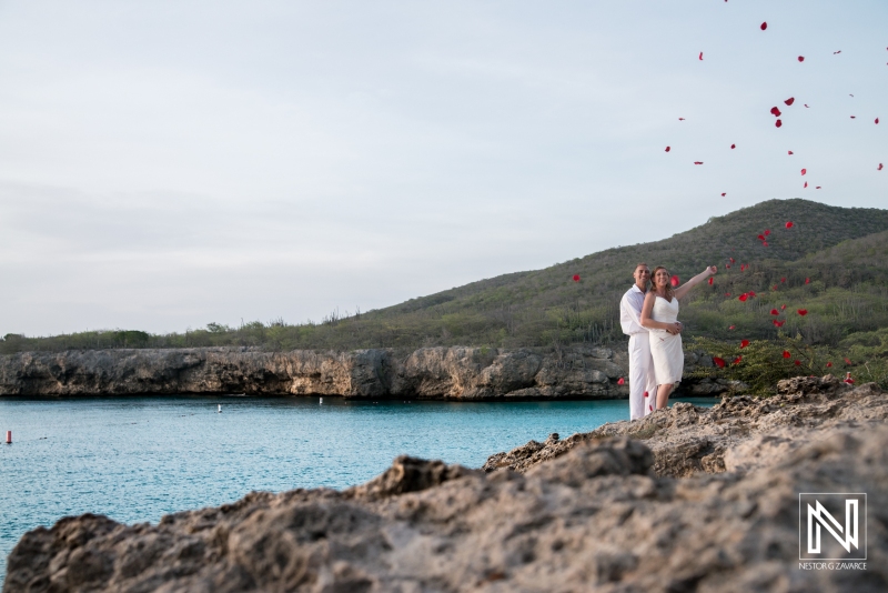 Bride and groom with rain of rose petals on the beach