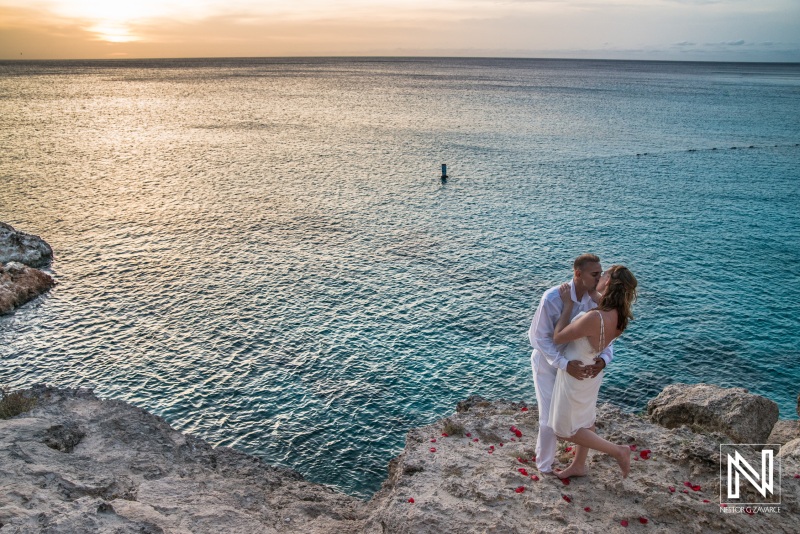 Bride and groom kissing on the beach with a beautiful sunset