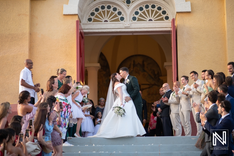 Bride and groom kiss at the entrance of the church