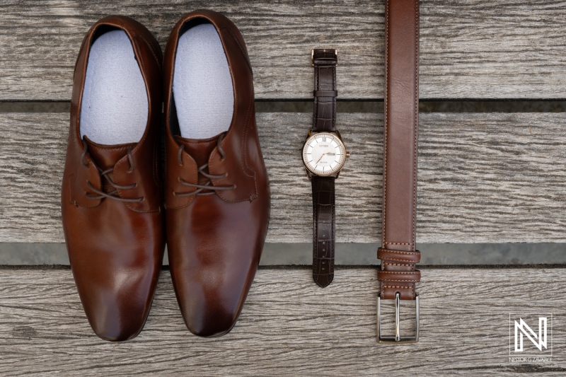 Elegant Brown Leather Shoes, a Classic Brown Belt, and a Stylish Brown Wristwatch Arranged Neatly on a Wooden Surface for a Sophisticated Fashion Display