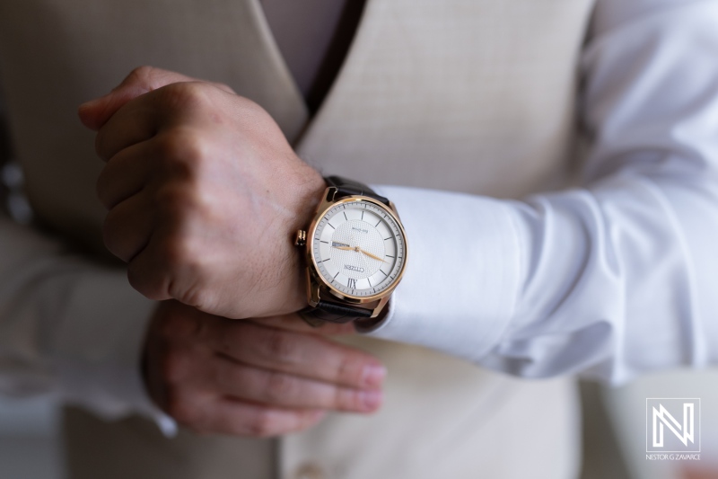 A Close-Up of a Man\'s Hand Adjusting a Stylish Watch While Dressed Elegantly in a Suit, Captured Indoors During a Special Event or Gathering