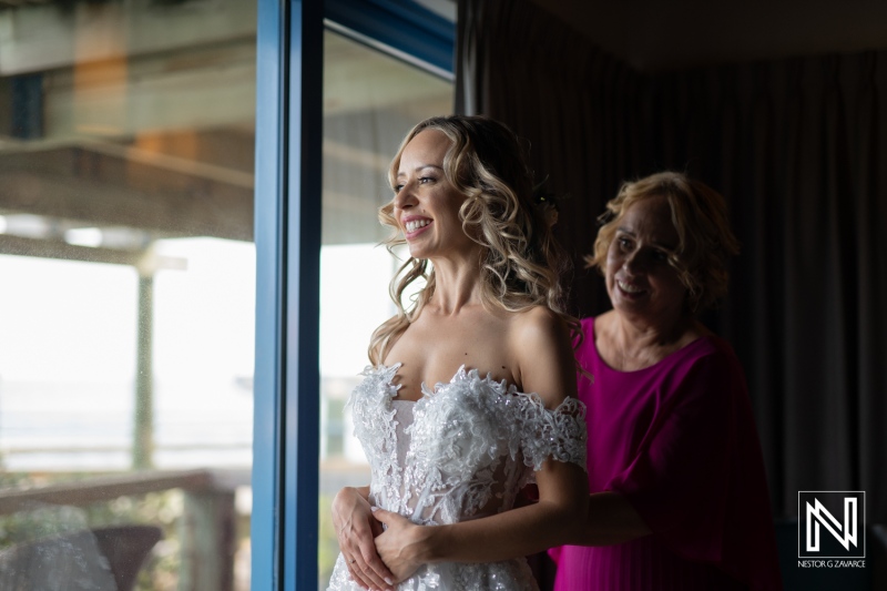 Bride Getting Ready With Her Mother in a Beautifully Lit Room Overlooking the Outdoor Scenery on Her Wedding Day