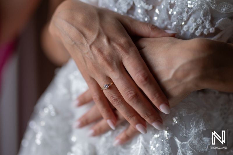 A Close-Up of a Bride\'s Hands Gently Cradling Her Wedding Dress, Highlighting the Elegant Ring, During a Serene Morning in a Softly Lit Room Filled With Anticipation