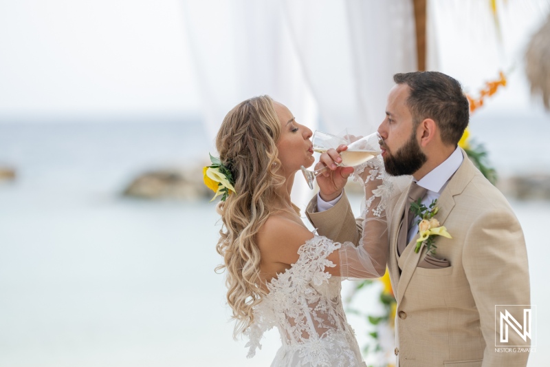 A Couple Shares a Romantic Toast With Champagne on the Beach During Their Wedding Ceremony in a Picturesque Coastal Setting at Sunset