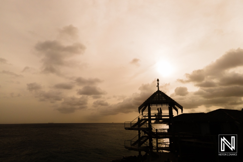 Silhouetted Lifeguard Tower on the Coast at Dusk, With a Cloudy Sky and Serene Ocean Waves in the Background, Creating a Tranquil Atmosphere During the Evening Hours