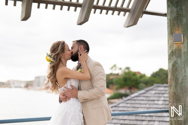 A Romantic Beach Wedding Moment Between a Couple Sharing a Tender Kiss on a Seaside Balcony During Sunset