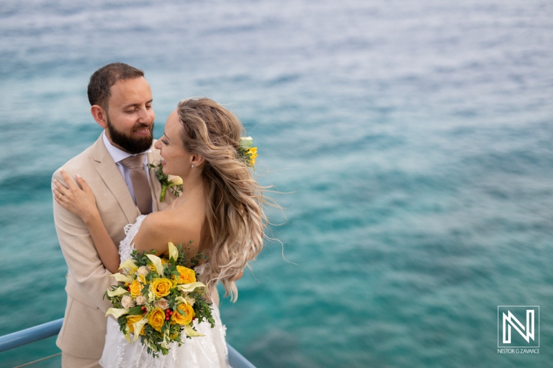 Couple Celebrating Their Wedding on a Beautiful Seaside Deck, Surrounded by Stunning Ocean Views and Vibrant Floral Arrangements