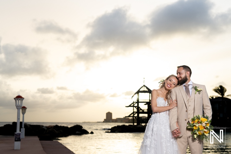 A Joyful Couple Celebrates Their Wedding on a Serene Beach at Sunset, Captured in an Intimate Moment With the Ocean and Palm Trees in the Background