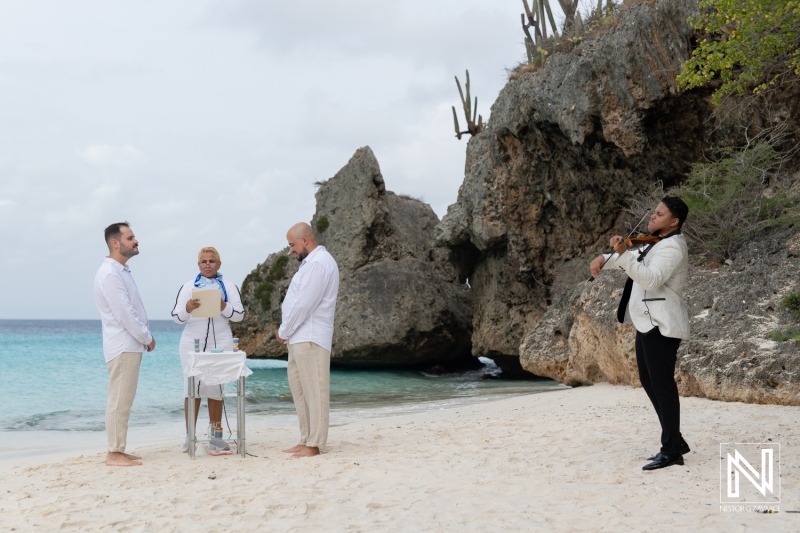 LGBT wedding ceremony at sunrise on Cas Abao Beach, Curacao with a beautiful backdrop of ocean and rocky coastline
