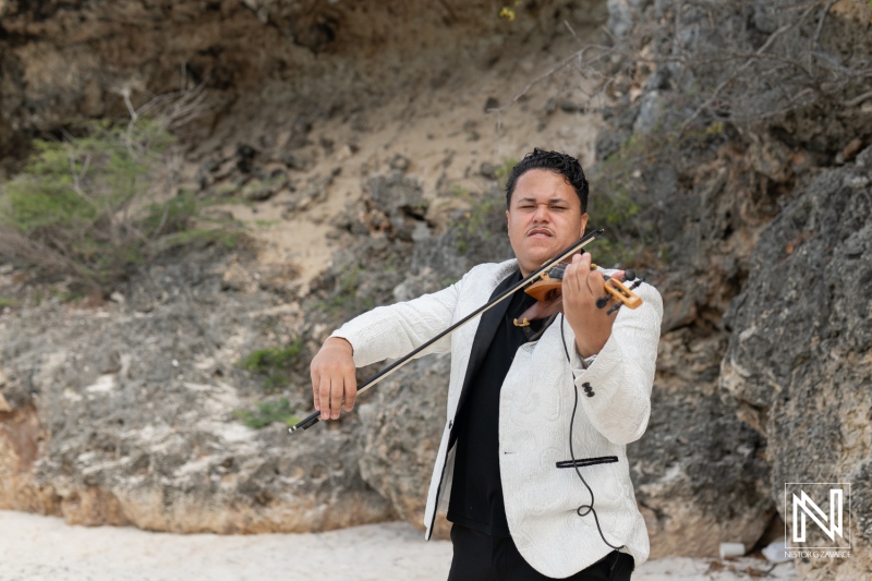 Violinist performs at LGBT wedding celebration during sunrise at Cas Abao Beach in Curacao