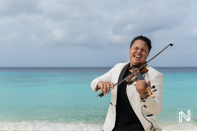 Vibrant musician celebrates LGBT wedding at sunrise on Cas Abao Beach in Curacao