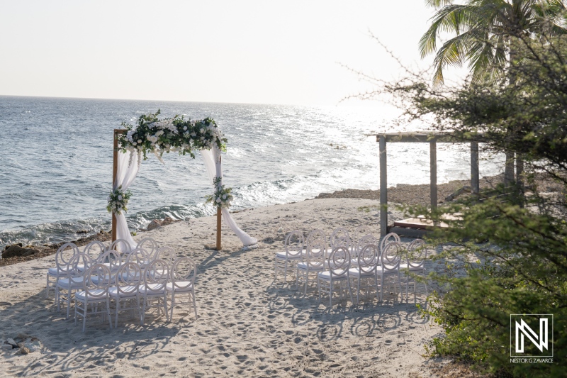 Stunning beach wedding setup at Coral Estate Luxury Resort in Curacao featuring elegant chairs and floral decorations by the ocean