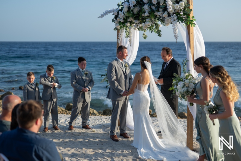 Elegant wedding ceremony on the beach at Coral Estate Luxury Resort in Curacao with stunning ocean backdrop and joyful guests celebrating love