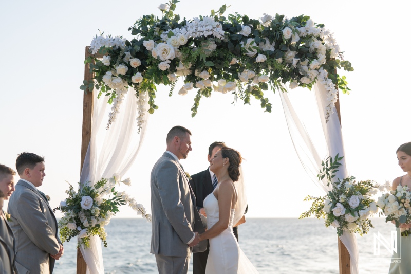 Wedding ceremony at Coral Estate Luxury Resort in Curacao overlooking the ocean with stunning floral arrangements