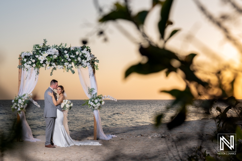 Couple shares a romantic moment during their wedding ceremony at Coral Estate Luxury Resort in Curacao at sunset