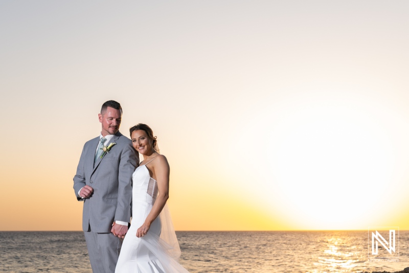 Couple celebrates their wedding at Coral Estate Luxury Resort in Curacao with a stunning ocean backdrop during sunset